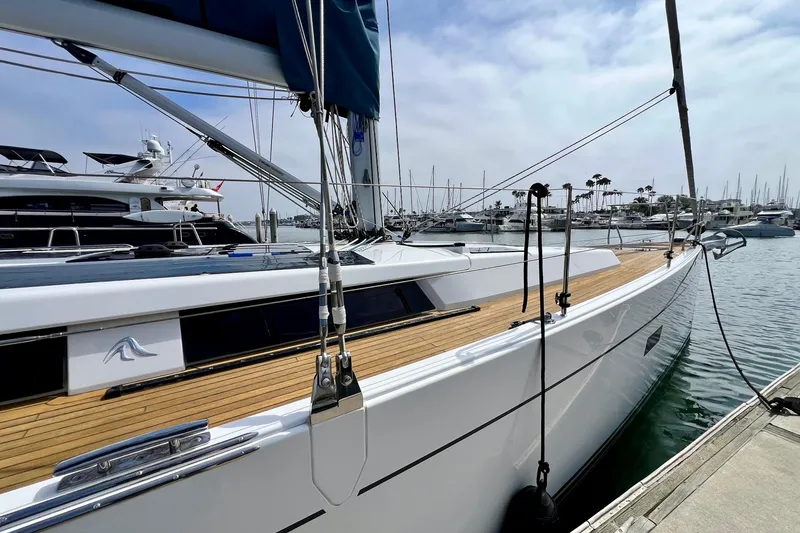 Slide: The Image of 2016 Hanse 455 yacht docked at marina, showcasing sleek design and wooden deck. - 21
