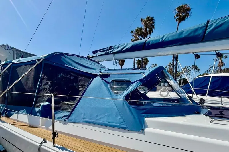 Slide: The Image of 2016 Hanse 455 sailboat with blue canopy, docked under clear skies and palm trees. - 24