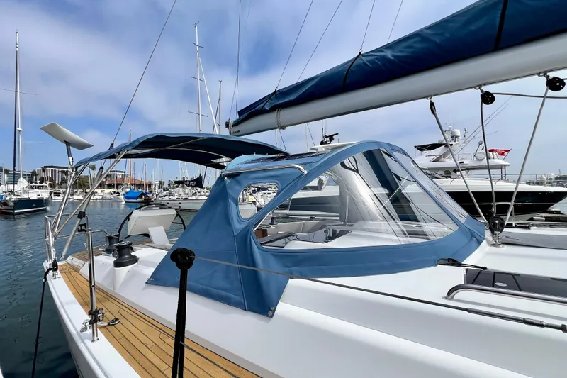 Slide: The Image of 2016 Hanse 455 sailboat docked in marina, featuring blue canopy and sleek design. - 25