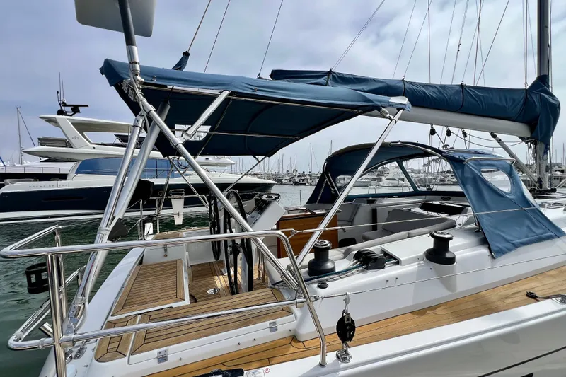 Slide: The Image of 2016 Hanse 455 sailboat with blue canopy, docked in a marina. - 26