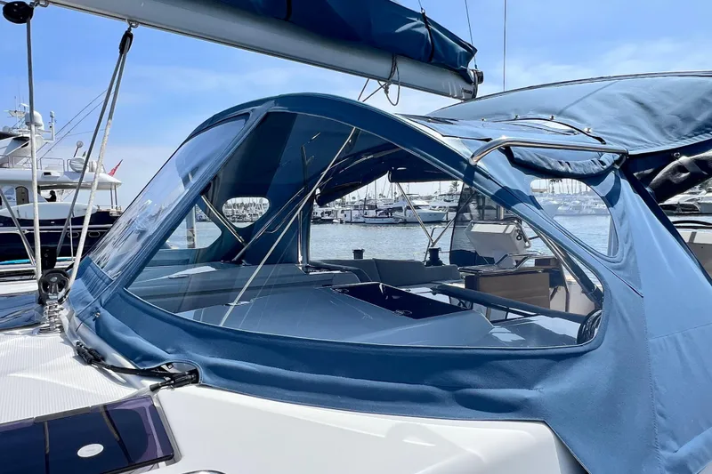 Slide: The Image of 2016 Hanse 455 sailboat with blue canopy docked at marina. - 31