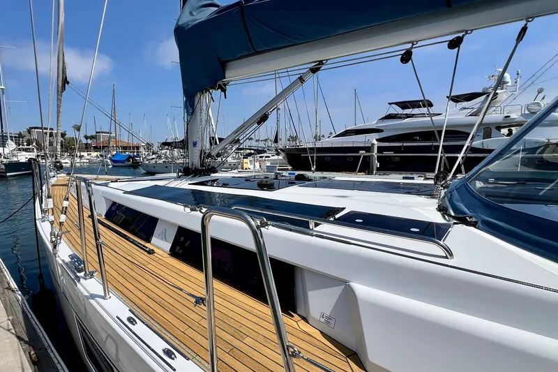 Slide: The Image of 2016 Hanse 455 yacht docked in marina, featuring sleek design and wooden deck. - 32