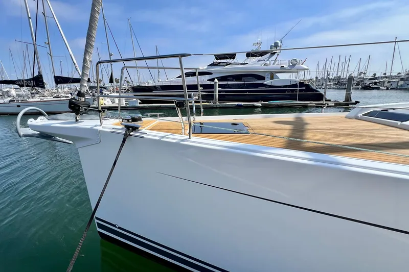 Slide: The Image of 2016 Hanse 455 yacht docked in marina, showcasing sleek design and wooden deck. - 33