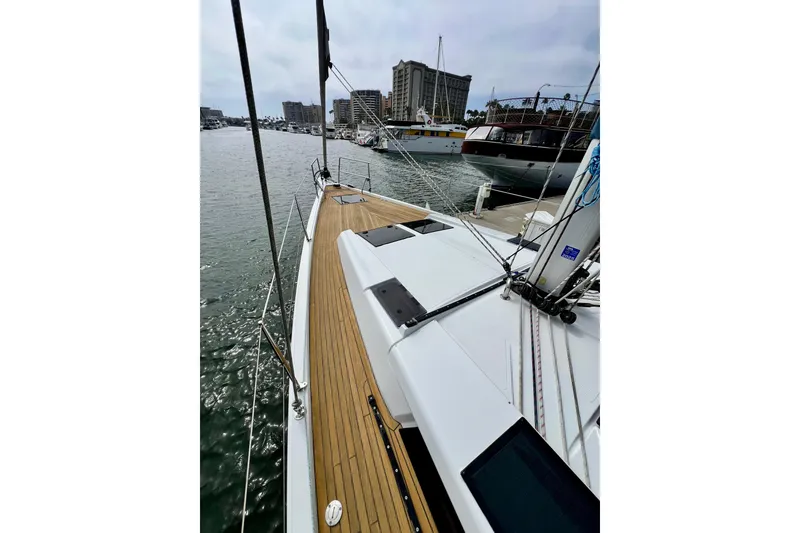 Slide: The Image of 2016 Hanse 455 sailboat docked in marina, showcasing sleek deck design and urban skyline. - 46
