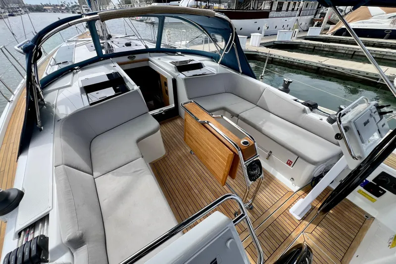 Slide: The Image of 2016 Hanse 455 yacht cockpit with cushioned seating and wooden flooring at marina. - 50