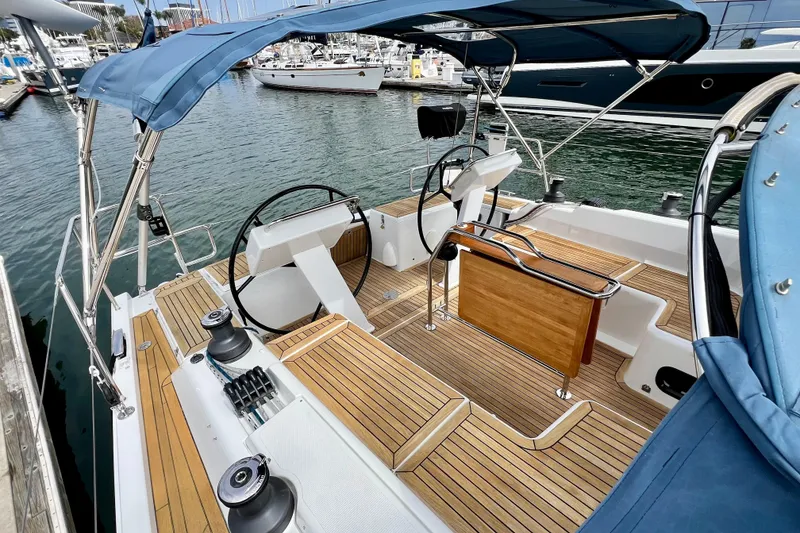 Slide: The Image of 2016 Hanse 455 sailboat cockpit with dual steering wheels and teak decking at marina. - 52