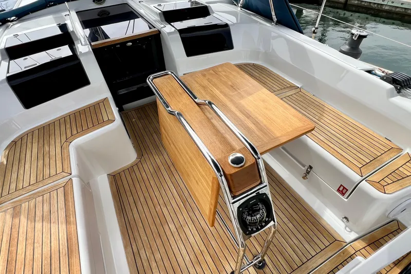 Slide: The Image of Cockpit of 2016 Hanse 455 sailboat with teak flooring and foldable wooden table. - 56