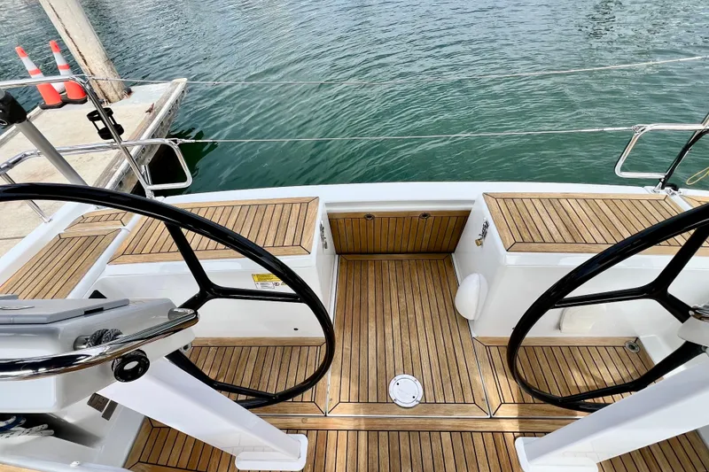 Slide: The Image of Cockpit of 2016 Hanse 455 sailboat with dual steering wheels and teak flooring. - 62