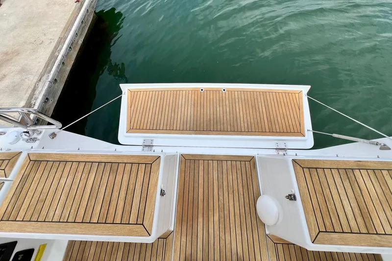 Slide: The Image of Teak deck of 2016 Hanse 455 yacht at marina, showcasing elegant wood finish. - 63