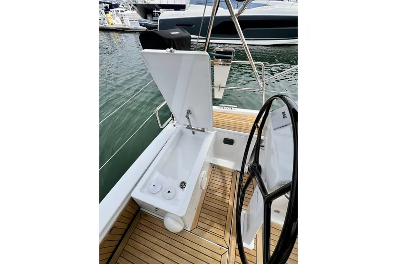 Slide: The Image of Cockpit of 2016 Hanse 455 yacht with open storage compartment and steering wheel. - 68