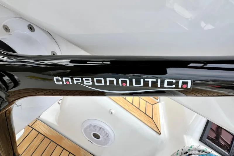 Slide: The Image of Carbonautica steering wheel on 2016 Hanse 455 yacht, featuring sleek black design and wooden deck. - 77