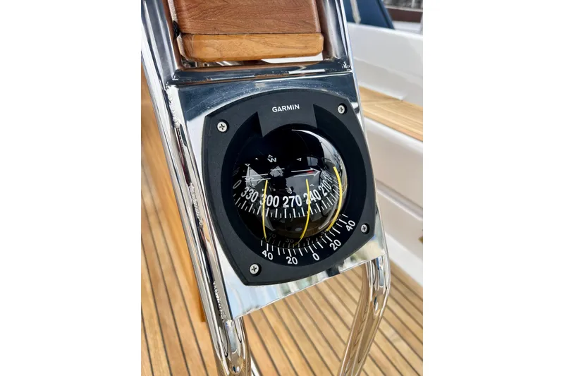Slide: The Image of Compass on 2016 Hanse 455 yacht, featuring Garmin navigation, with teak deck background. - 78