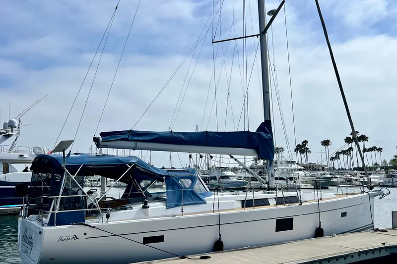 Slide: The Image of 2016 Hanse 455 sailboat docked at marina with blue canopy and clear sky. - 8