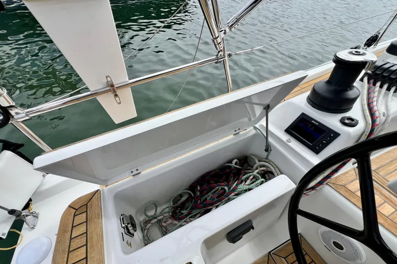 Slide: The Image of Open storage compartment on 2016 Hanse 455 sailboat, showing ropes and control panel. - 84