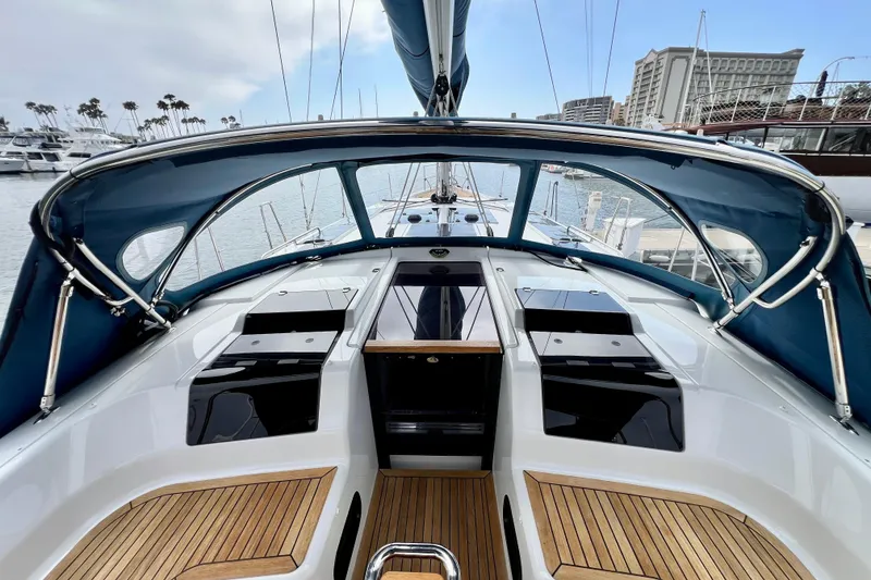 Slide: The Image of Interior view of a 2016 Hanse 455 sailboat cockpit with wooden flooring and blue canopy. - 90
