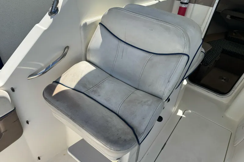 Slide: The Image of Captain's seat on 2005 Bayliner 222 Classic boat, white upholstery, interior view. - 16