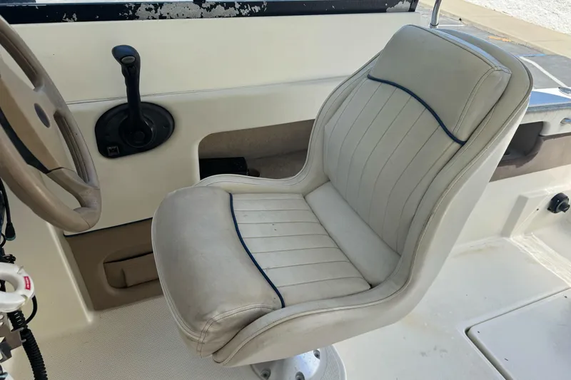 Slide: The Image of Captain's seat and steering wheel of a 2005 Bayliner 222 Classic boat. - 18