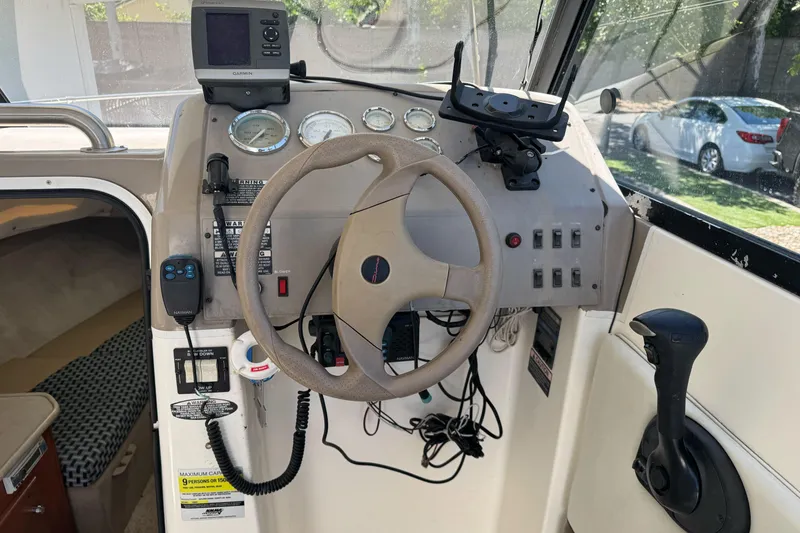 Slide: The Image of 2005 Bayliner 222 Classic boat dashboard with steering wheel and navigation instruments. - 19