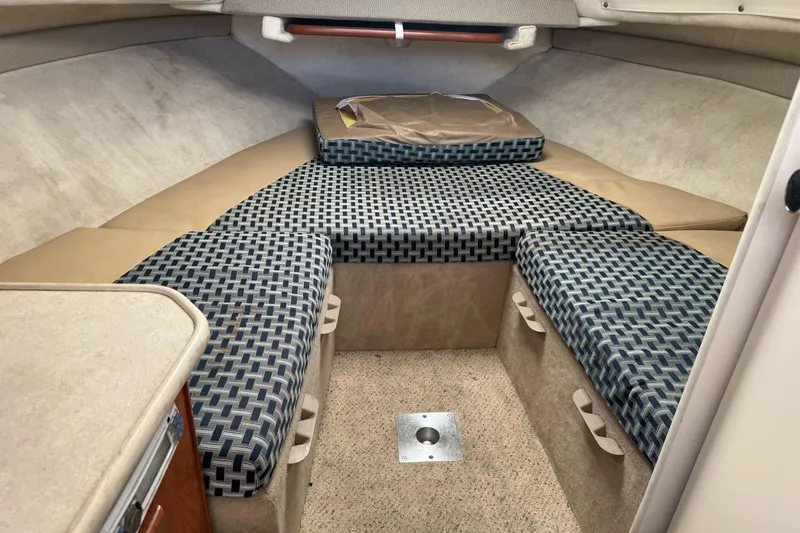 Slide: The Image of 2005 Bayliner 222 Classic cabin interior with patterned cushions and storage compartments. - 23