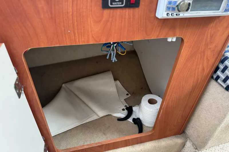 Slide: The Image of Storage compartment in a 2005 Bayliner 222 Classic boat with folded canvas and accessories. - 25