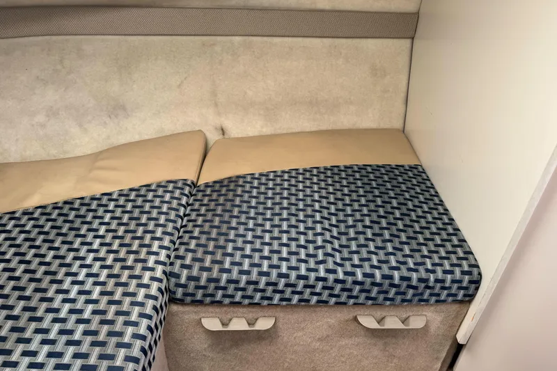 Slide: The Image of 2005 Bayliner 222 Classic cabin interior with patterned cushions and storage compartments. - 26