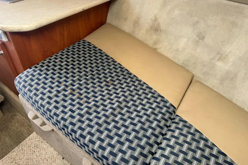 Slide: The Image of 2005 Bayliner 222 Classic boat interior with patterned seating and wooden cabinetry. - 29