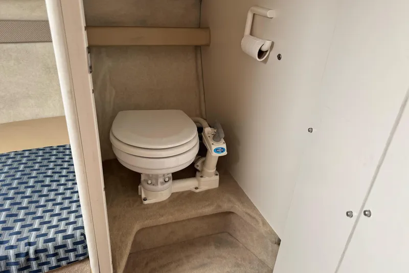 Slide: The Image of 2005 Bayliner 222 Classic boat interior with compact marine toilet and paper holder. - 32