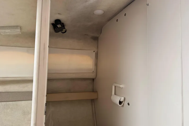 Slide: The Image of Interior cabin view of a 2005 Bayliner 222 Classic boat, featuring storage and lighting. - 33