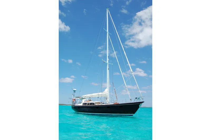 Slide: The Image of Sailing yacht Hutting 40', 1994 model, on turquoise sea under clear blue sky. - 1