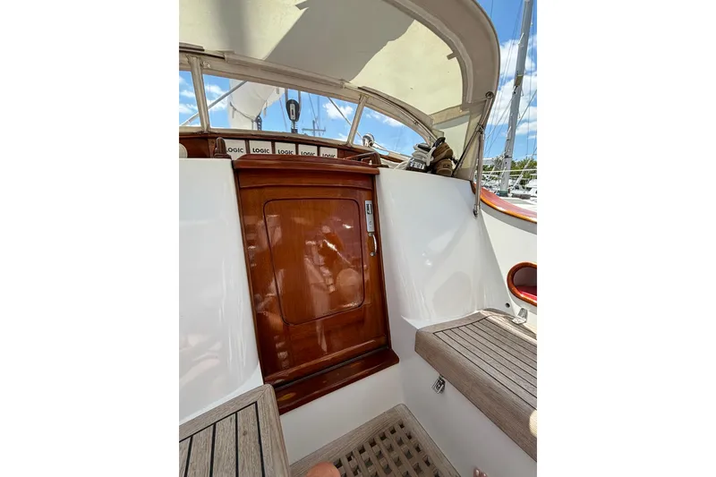 Slide: The Image of Interior view of a 1994 Hutting 40' sailboat, featuring wooden door and seating. - 19