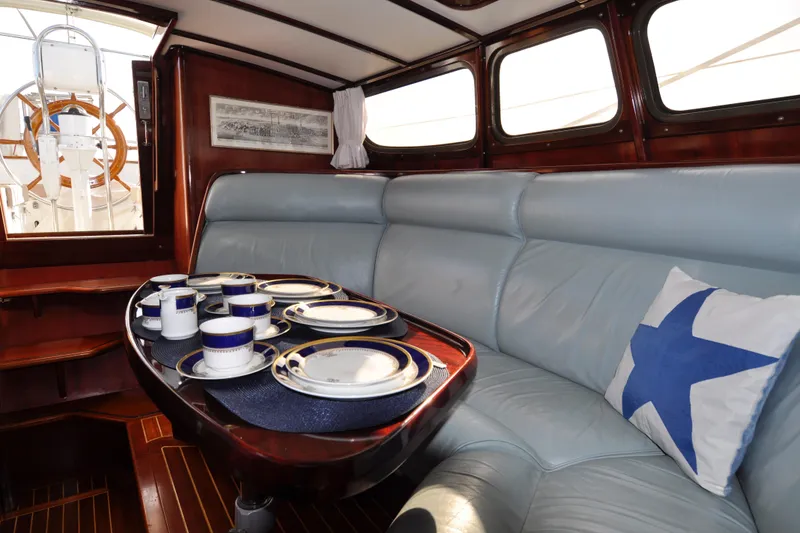 Slide: The Image of Luxurious 1994 Hutting 40' yacht interior with elegant dining setup and plush seating. - 25