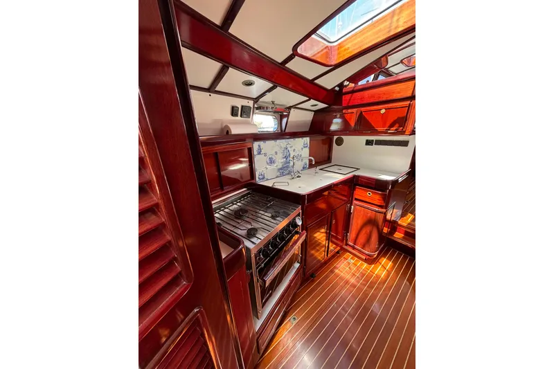 Slide: The Image of Luxurious 1994 Hutting 40' yacht interior with rich wood finishes and modern kitchen amenities. - 29