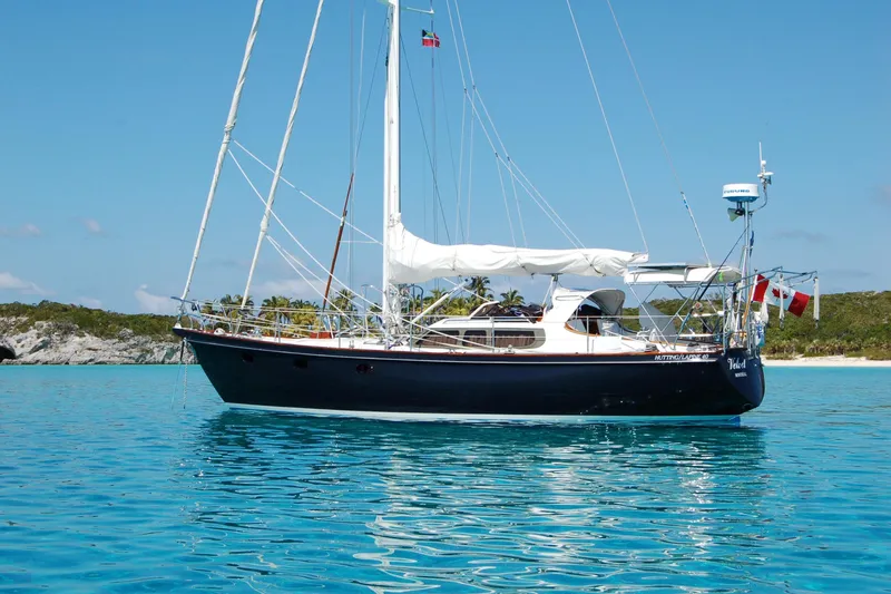 Slide: The Image of Sailing yacht Hutting 40', 1994 model, anchored in clear blue waters with scenic background. - 3