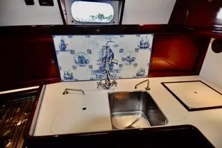 Slide: The Image of 1994 Hutting 40' yacht kitchen with nautical-themed backsplash and stainless steel sink. - 30