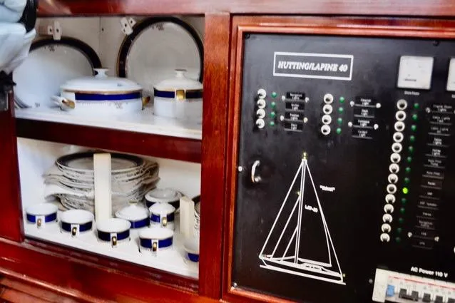 Slide: The Image of Wooden cabinet with dishes and control panel on a 1994 Hutting 40' sailboat. - 31
