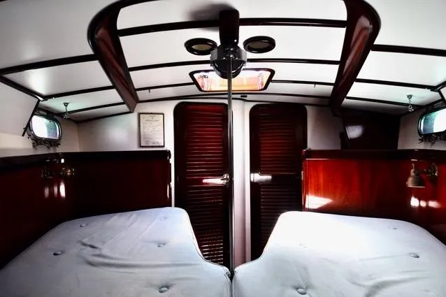 Slide: The Image of Interior of a 1994 Hutting 40' yacht cabin with twin beds and wooden finishes. - 41
