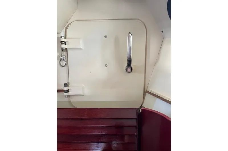 Slide: The Image of Interior view of a 1994 Hutting 40' yacht, featuring a cabin door with a metal handle. - 42