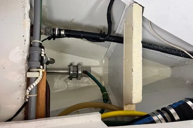 Slide: The Image of Interior view of a 1994 Hutting 40' boat showing plumbing and wiring components. - 49