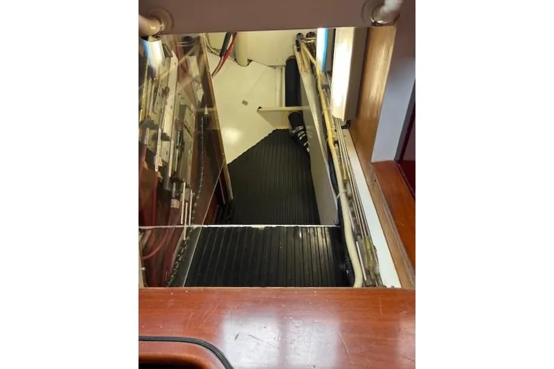 Slide: The Image of Interior view of a 1994 Hutting 40' yacht engine compartment with visible wiring and components. - 51