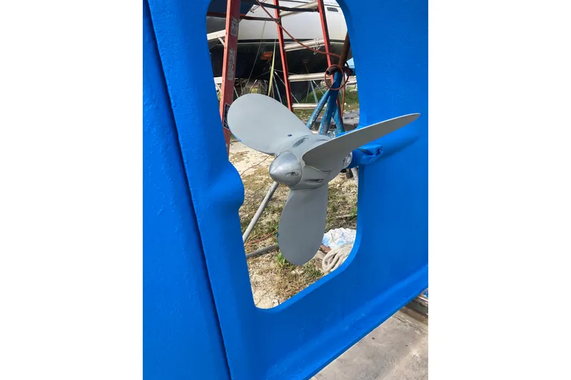 Slide: The Image of Blue-painted boat hull with a propeller, Hutting 40', 1994 model, in a shipyard setting. - 54