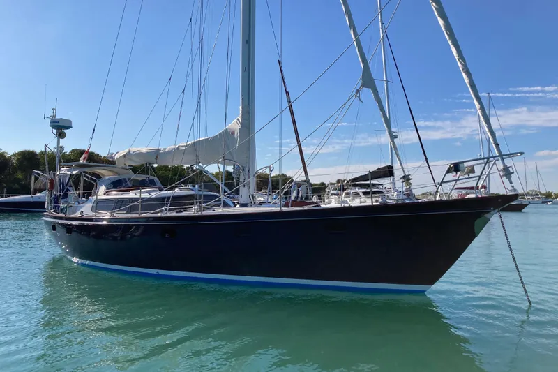 Slide: The Image of Sailing yacht on water, 1994 Hutting 40' model, clear sky, marina background. - 55