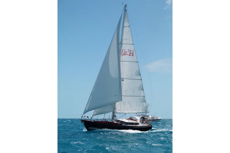 Slide: The Image of Sailing yacht Hutting 40', 1994 model, gliding on blue ocean under clear sky. - 56