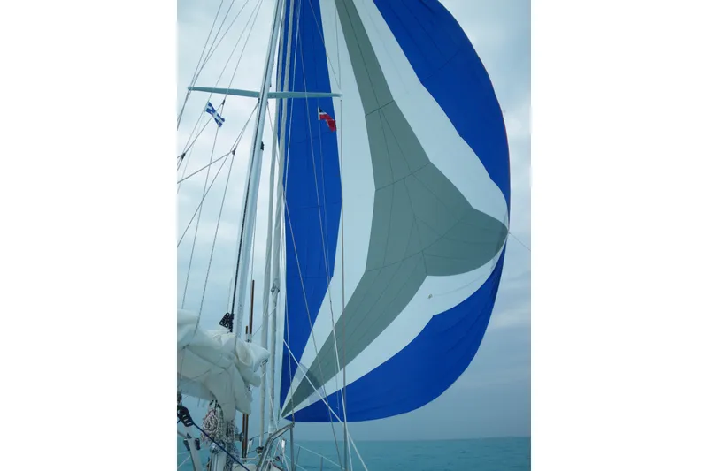 Slide: The Image of Sailing yacht with blue and gray spinnaker, Hutting 40', 1994 model, on open sea. - 57