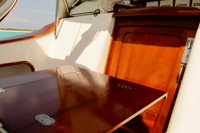 Slide: The Image of Polished wooden interior of a 1994 Hutting 40' sailboat, featuring a foldable table. - 8