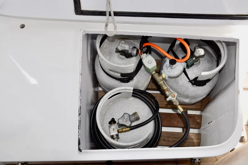 Slide: The Image of Storage compartment with gas cylinders and hoses on a 1994 Hutting 40' boat. - 9