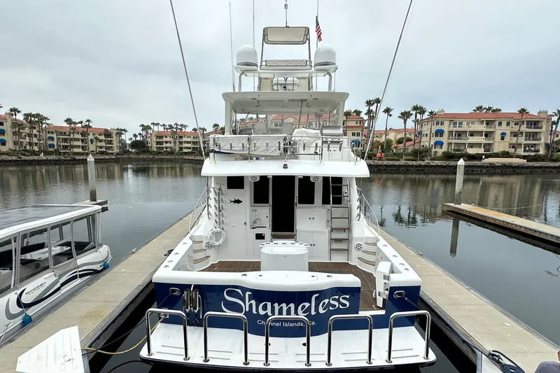 Slide: The Image of 2004 Mikelson 61 PH yacht docked in a marina, surrounded by waterfront buildings. - 11