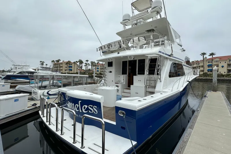 Slide: The Image of 2004 Mikelson 61 PH yacht docked at marina, featuring sleek design and spacious deck. - 2