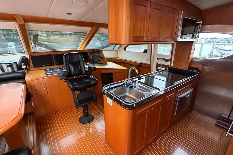 Slide: The Image of Luxurious 2004 Mikelson 61 PH yacht interior with helm, kitchen, and wood finishes. - 4