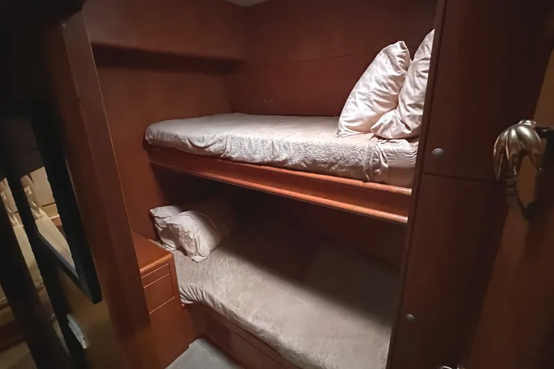 Slide: The Image of Bunk beds in 2004 Mikelson 61 PH yacht cabin, featuring wooden interior and cozy bedding. - 9