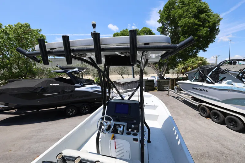 Slide: The Image of 2021 Blazer Bay 2400 boat with T-top, parked alongside other boats in a sunny marina. - 13